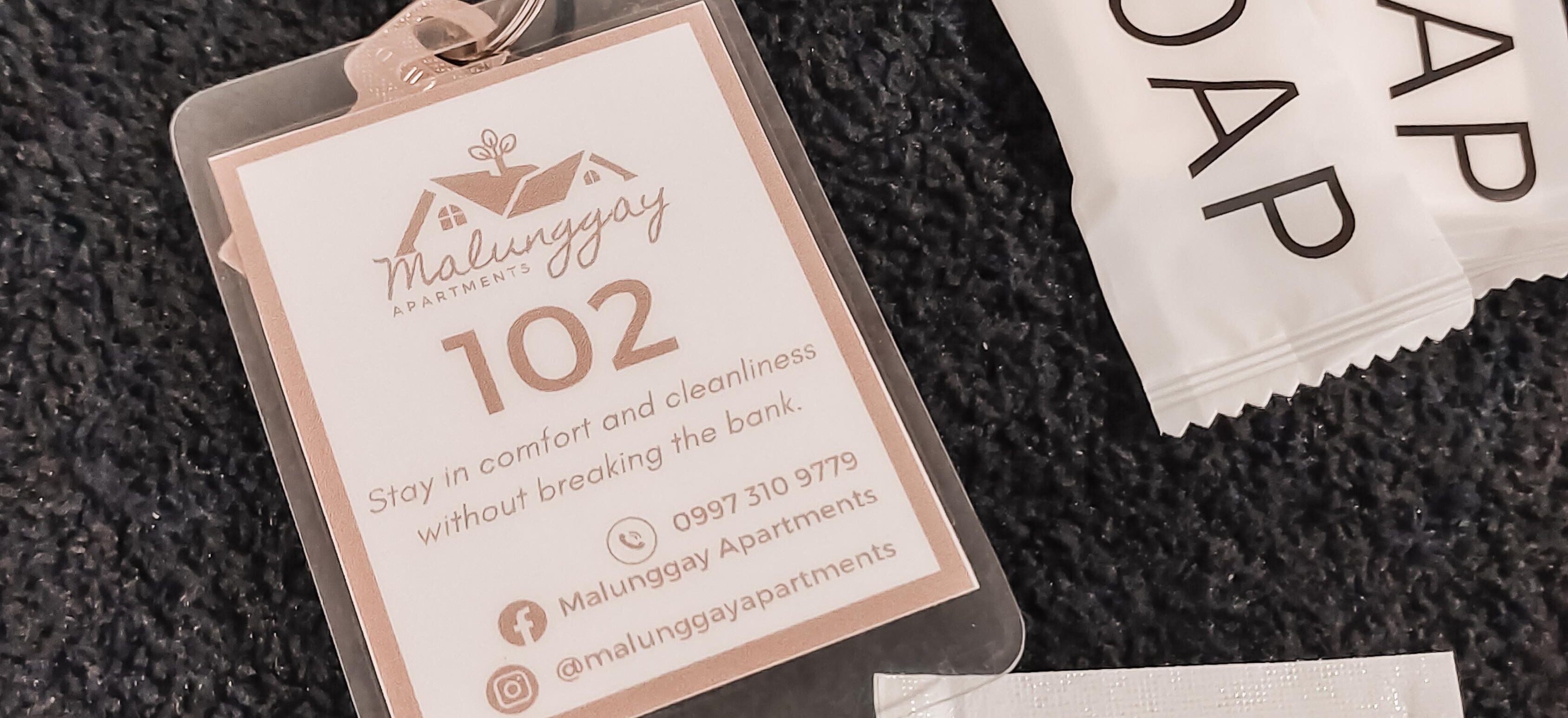 A tag with the text "Malunggay Apartments 102" and contact information.