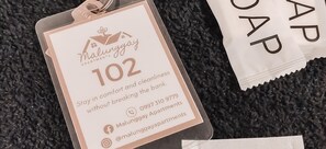 Una etiqueta con el texto 'Malunggay Apartments 102' e información de contacto.