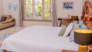 A bedroom with a large bed, a window with curtains, a desk with a lamp, and a chair. - The vintage manor (Blantyre)