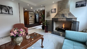 Uma sala de estar moderna com lareira, um sofá, uma mesa de centro e uma poltrona.