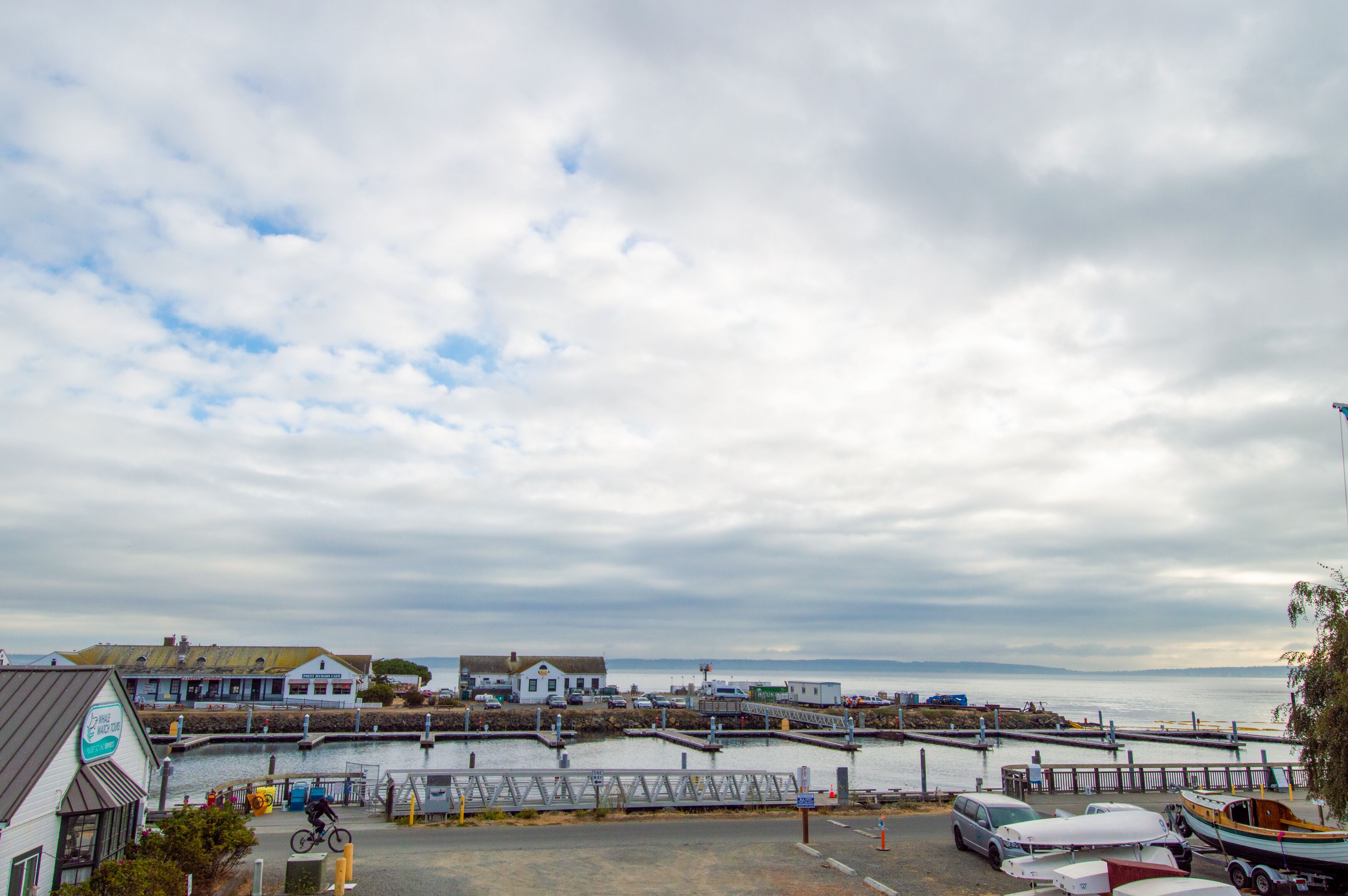 A coastal town with a marina, a bridge, and buildings along the waterfront.
