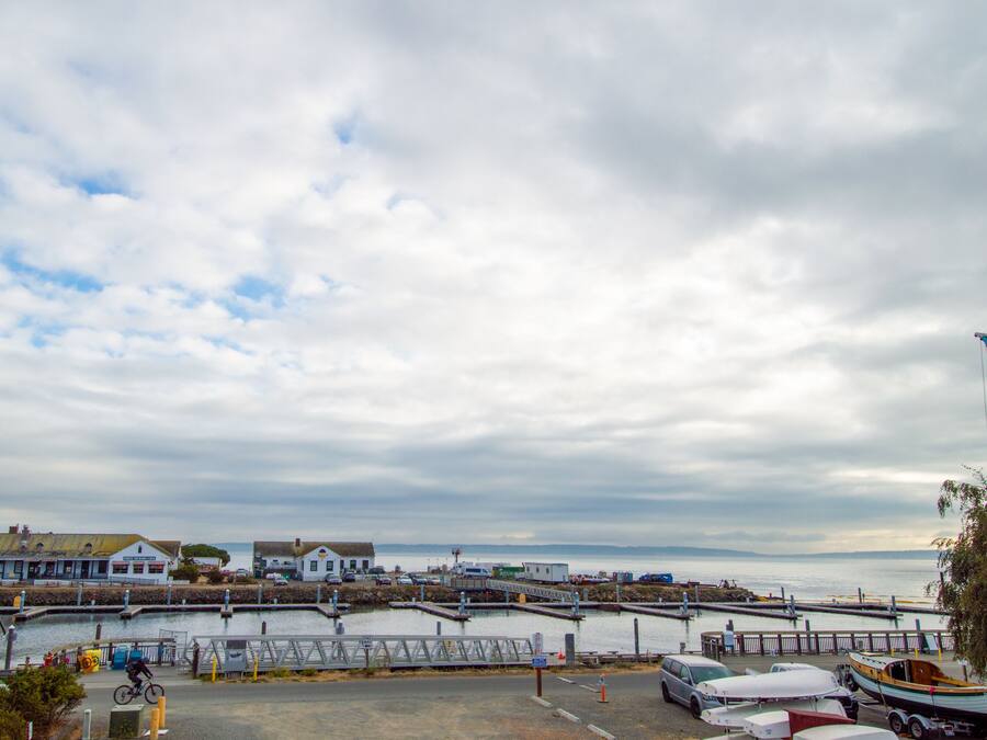 A coastal town with a marina, a bridge, and buildings along the waterfront.