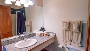 A bathroom with a sink, mirror, towel rack, and toilet.