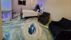 Ein Hotelzimmer mit einem Bett, einem schwarzen Sessel und einem einzigartigen Marmorboden-Design.