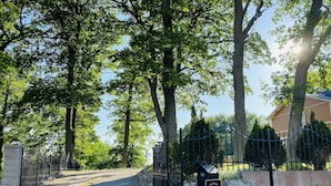 Ein Schotterweg führt zu einem verschlossenen Eingang mit einem Schild, auf dem 'Privat Omrade' steht.