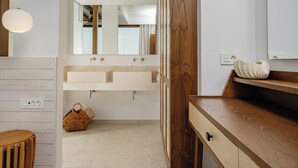 Un baño moderno con tocador de madera, un espejo grande y una lámpara.