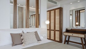 Un dormitorio moderno con una cama grande, un armario de madera y un tocador con espejo.