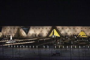 Un bâtiment moderne doté d’une façade géométrique et d’une imposante structure pyramidale.