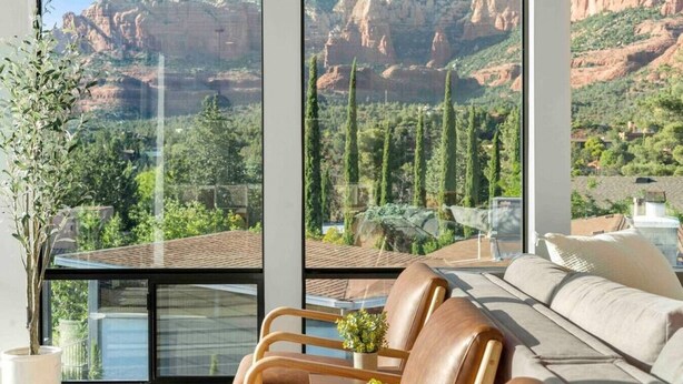A modern living room with a large window overlooking a mountainous landscape. - Ultimate Uptown Home Epic Views Private Pool and Spa (Sedona)