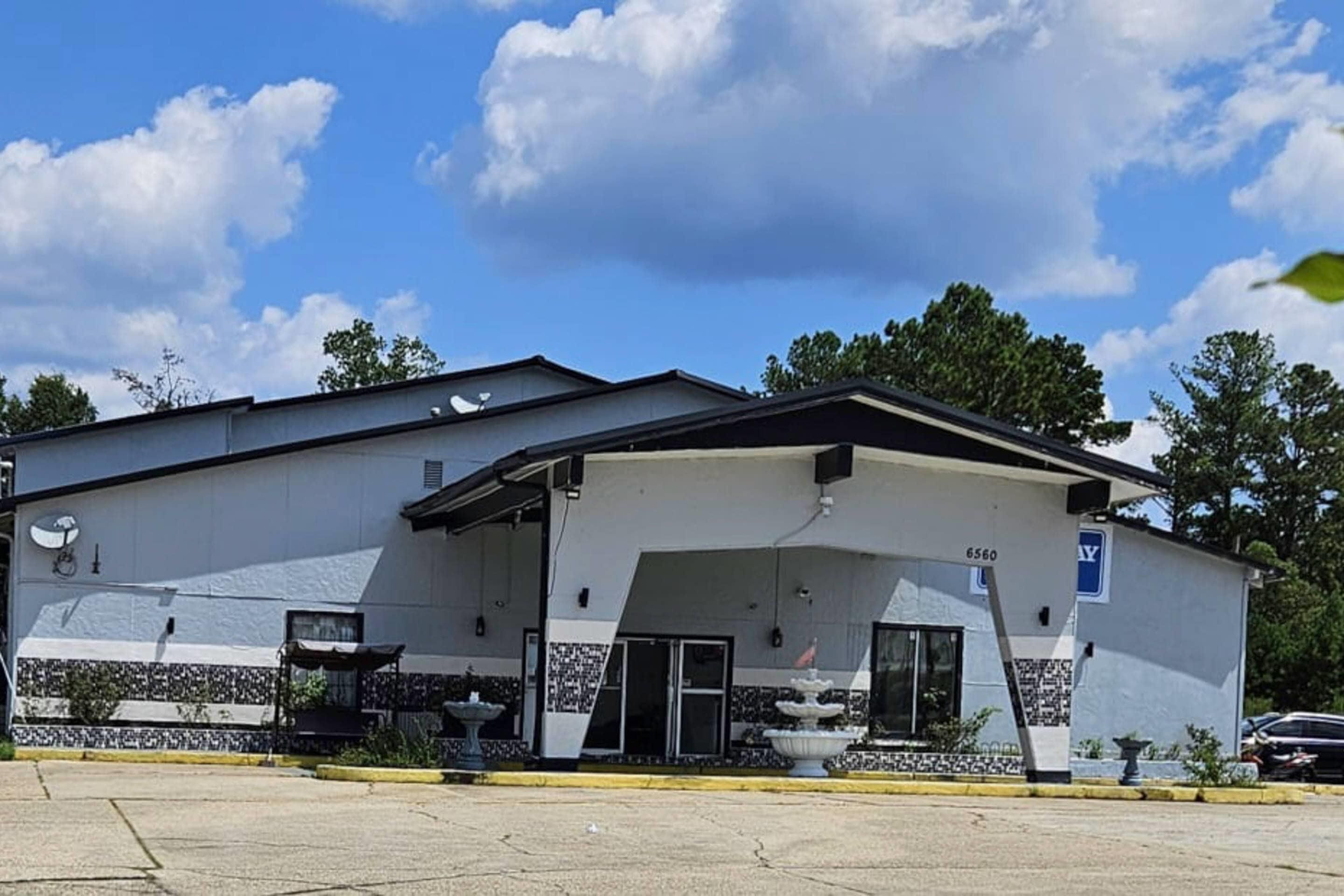 A building with a flat roof, a covered entrance, and a sign indicating a public restroom.