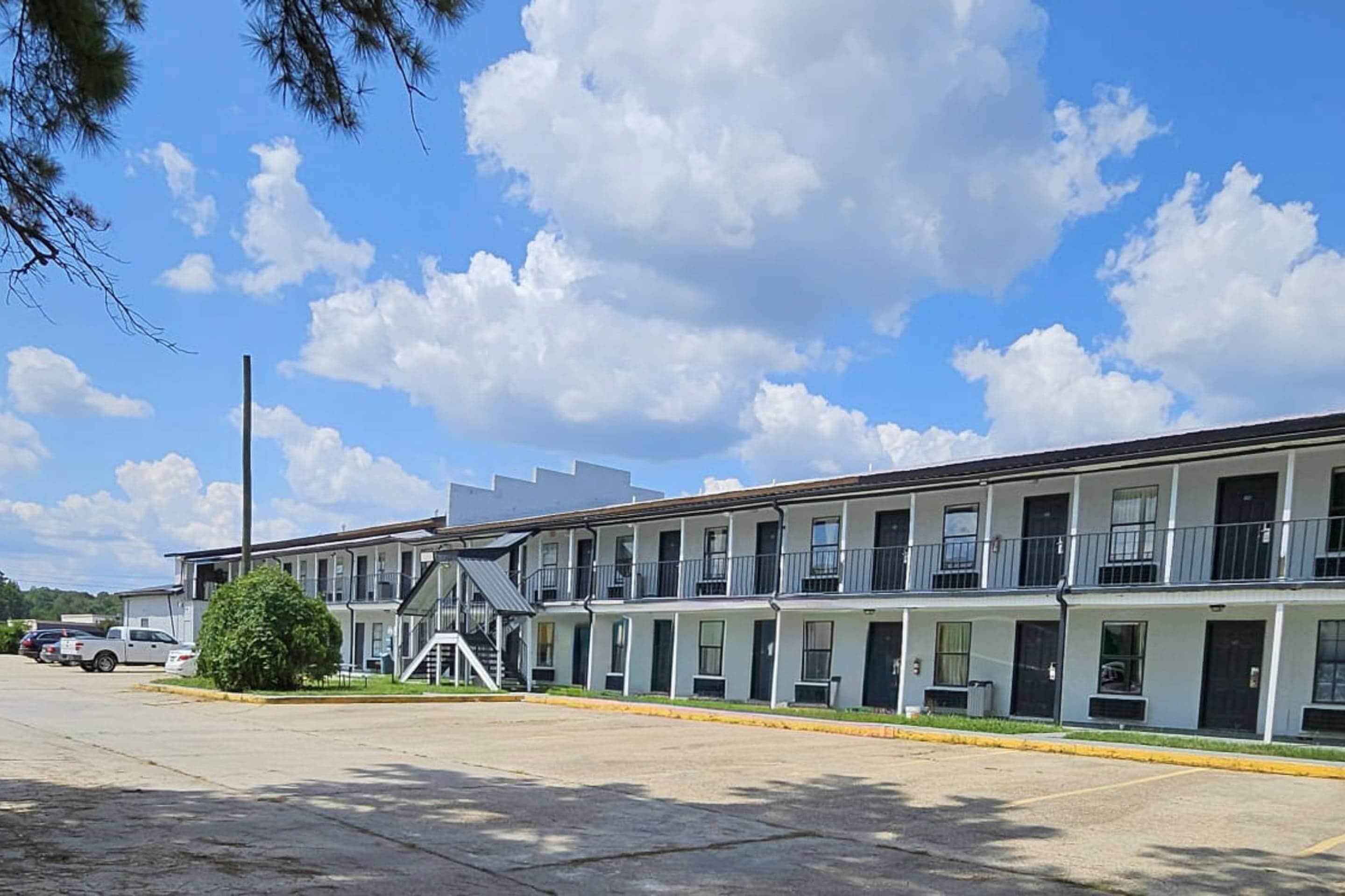 Un motel doté de nombreuses chambres, d’un parking couvert et offrant une vue sur un ciel dégagé.