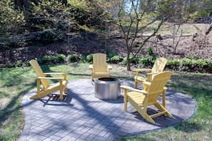 A patio with Adirondack chairs and a metal fire pit. - Uptown@ 8th Street - Unit 310 (Cullman)