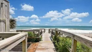 Un muelle de madera que conduce a una playa con cielo despejado.
