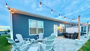 A patio with Adirondack chairs, a table, and string lights. - 3 Pools + Gameroom & Beach Shuttle Near Bethany Beach! (Millville)