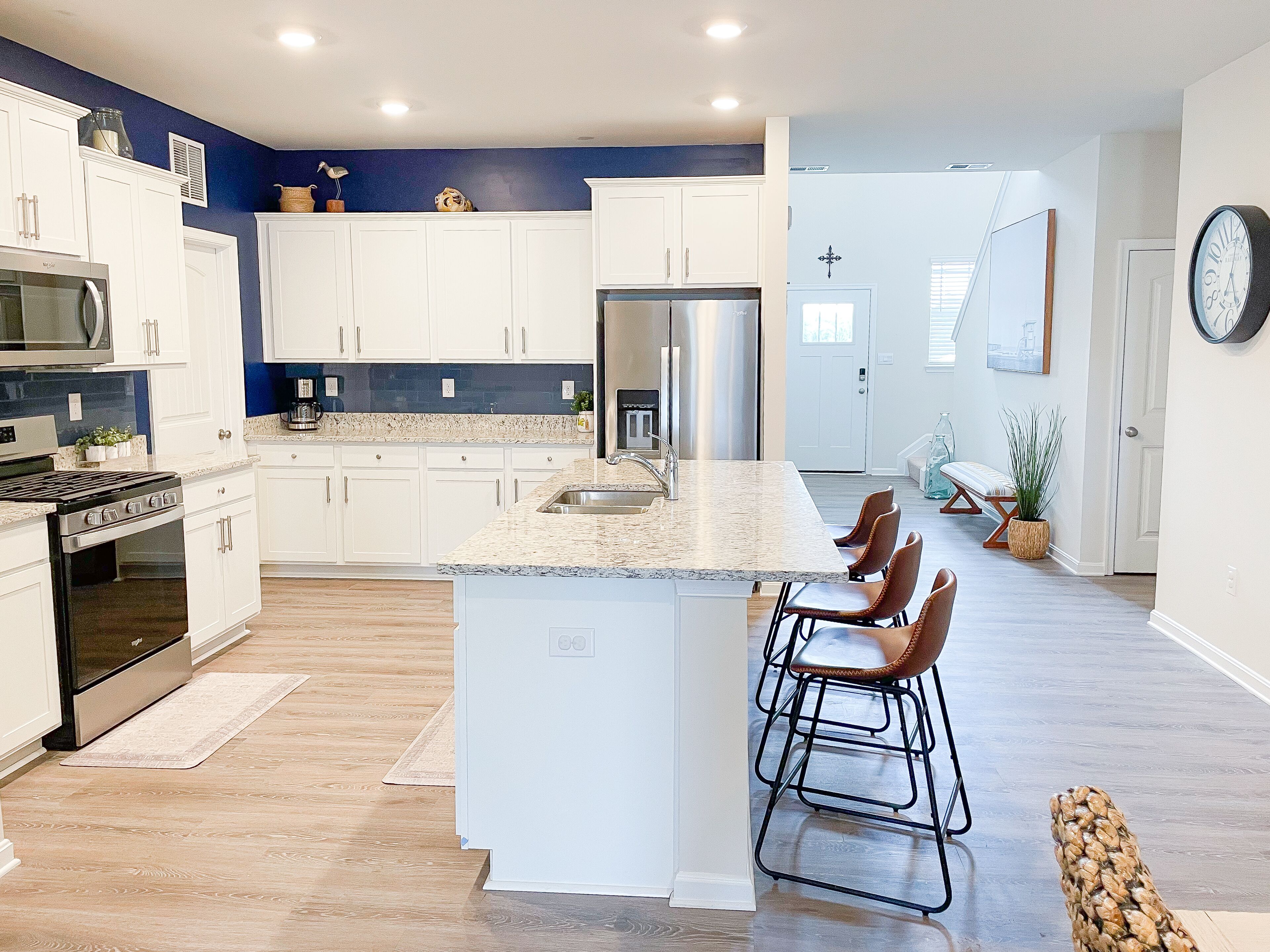 A modern kitchen with white cabinets, stainless steel appliances, and a granite countertop.