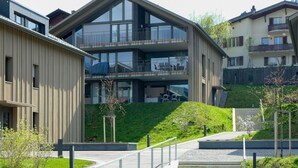 Een modern gebouw met een plat dak, grote ramen en een balkon.