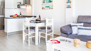 Een moderne keuken met witte kasten, een ingebouwde magnetron en een roestvrijstalen afzuigkap.