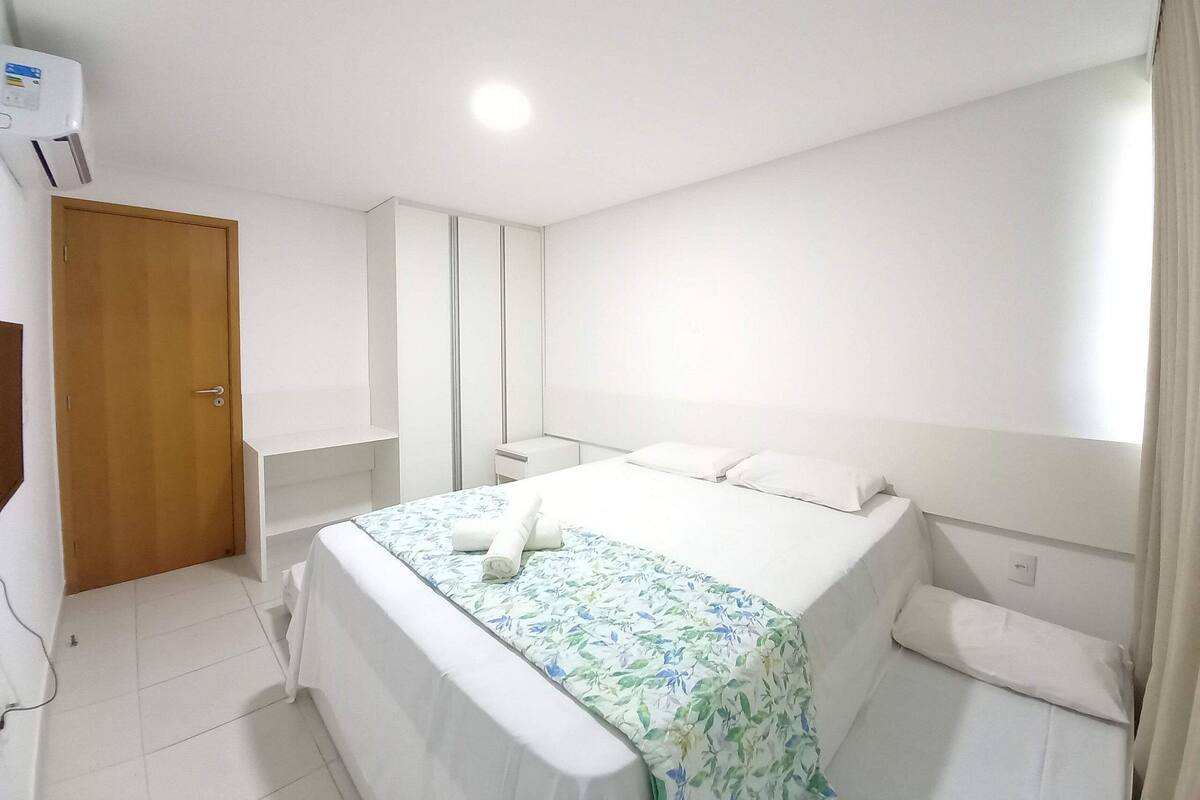 Ein Schlafzimmer mit Bett, Kleiderschrank, Tür und Fenster.
