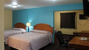 A hotel room with two beds, a desk, a chair, and a TV.
