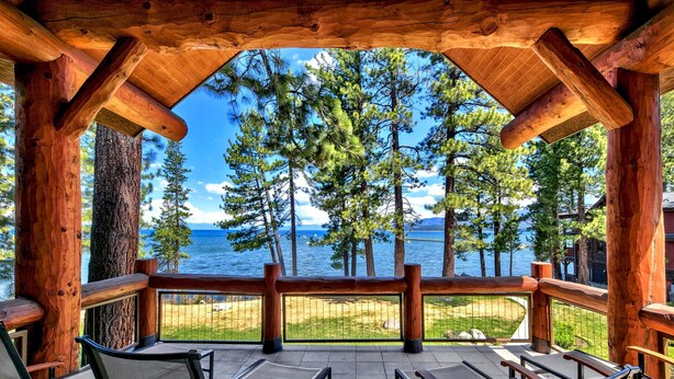 A wooden deck with chairs overlooking a lake and forest. - 8 Sierra Shores - Stunning Lakefront 4BR/4BA (South Lake Tahoe)