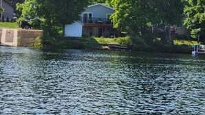 A house by a lake with a dock, surrounded by trees. - Water front Getaway (Sault Ste. Marie)