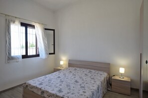 Cozy bedroom with a single bed, bedside tables, and a window with curtains.