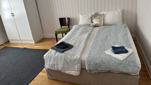 A bedroom with a bed, a wardrobe, a chair, and a rug. - Lovely Apartment in Stockholm City (Stockholm)
