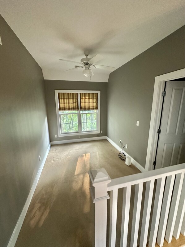 A room with a ceiling fan, a window with blinds, a door, and a white railing. - Modern Lakeshore Home! 2 minute drive to the beach! Community pool 3 houses away (Union Pier)