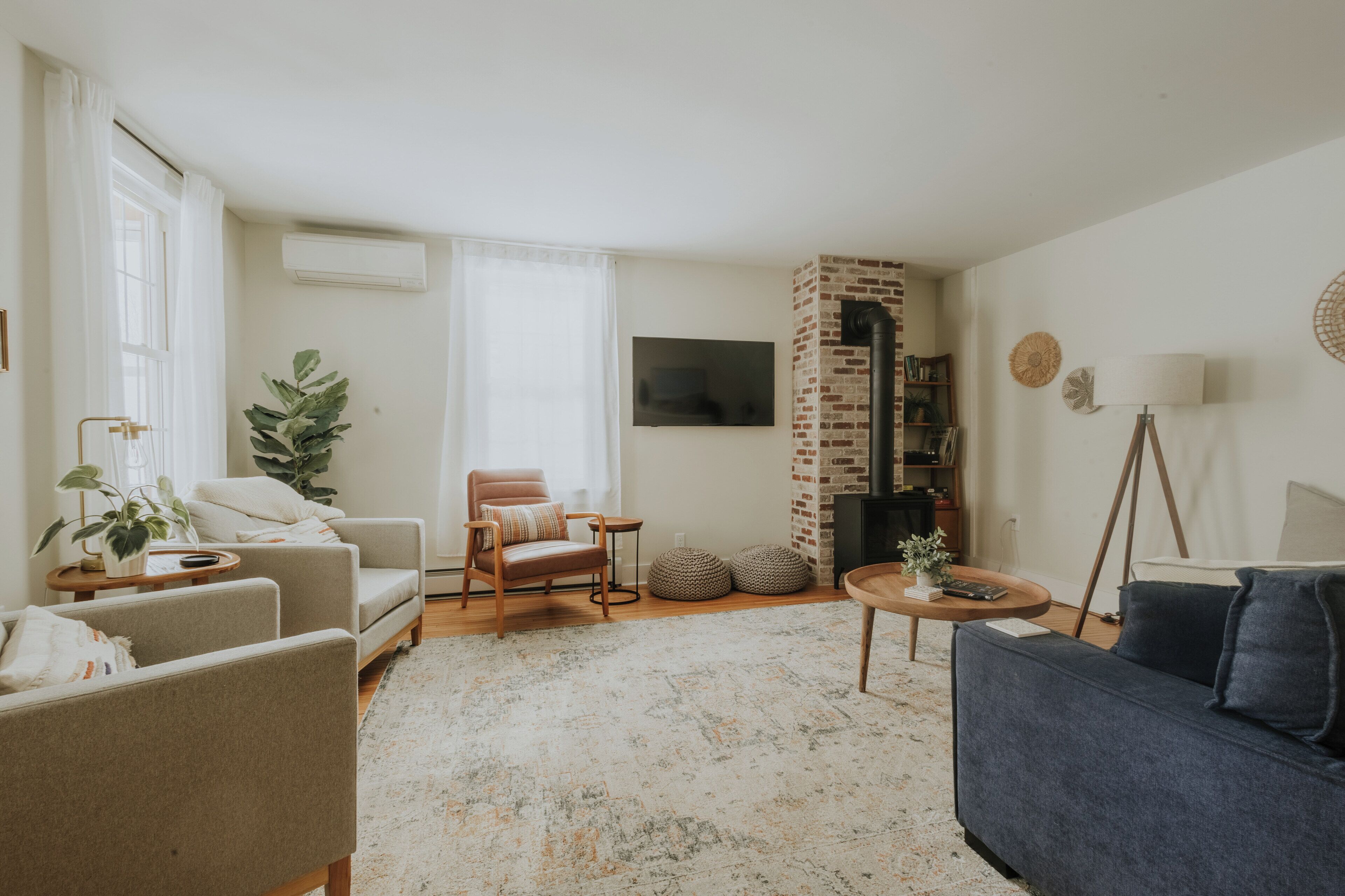 A living room with a sofa, armchairs, a coffee table, and a fireplace.