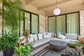 Relax in a stylish space with a large sofa, round coffee table, and lush greenery.