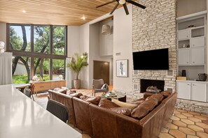 Relax in a spacious living area with a stone fireplace, flat-screen TV, and comfortable seating.
