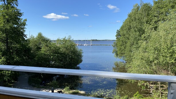A view of a lake with boats, surrounded by dense greenery and a clear sky. - Beautiful lake view house  (Vasteras)