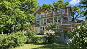 A two-story building with a balcony and a garden in front. - Beautiful lake view house  (Vasteras)