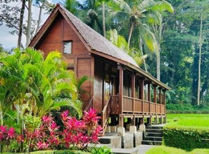 Escape to a serene retreat surrounded by lush tropical vegetation and a picturesque porch.