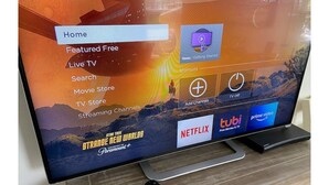Een televisiescherm toont een streamingdienstinterface met opties zoals Startscherm, Aanbevolen Gratis, Live TV en diverse streamingkanalen, waaronder Netflix en Prime Video.