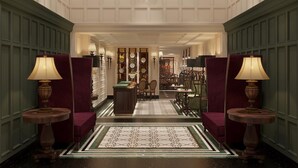 A grand lobby with a chandelier, green paneled walls, and a patterned floor. - Victor Metropolis Hotel & Rooftop bar (Hanoi)