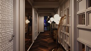 A hallway with a patterned wall, a wooden floor, and a gold floor lamp. - Victor Metropolis Hotel & Rooftop bar (Hanoi)