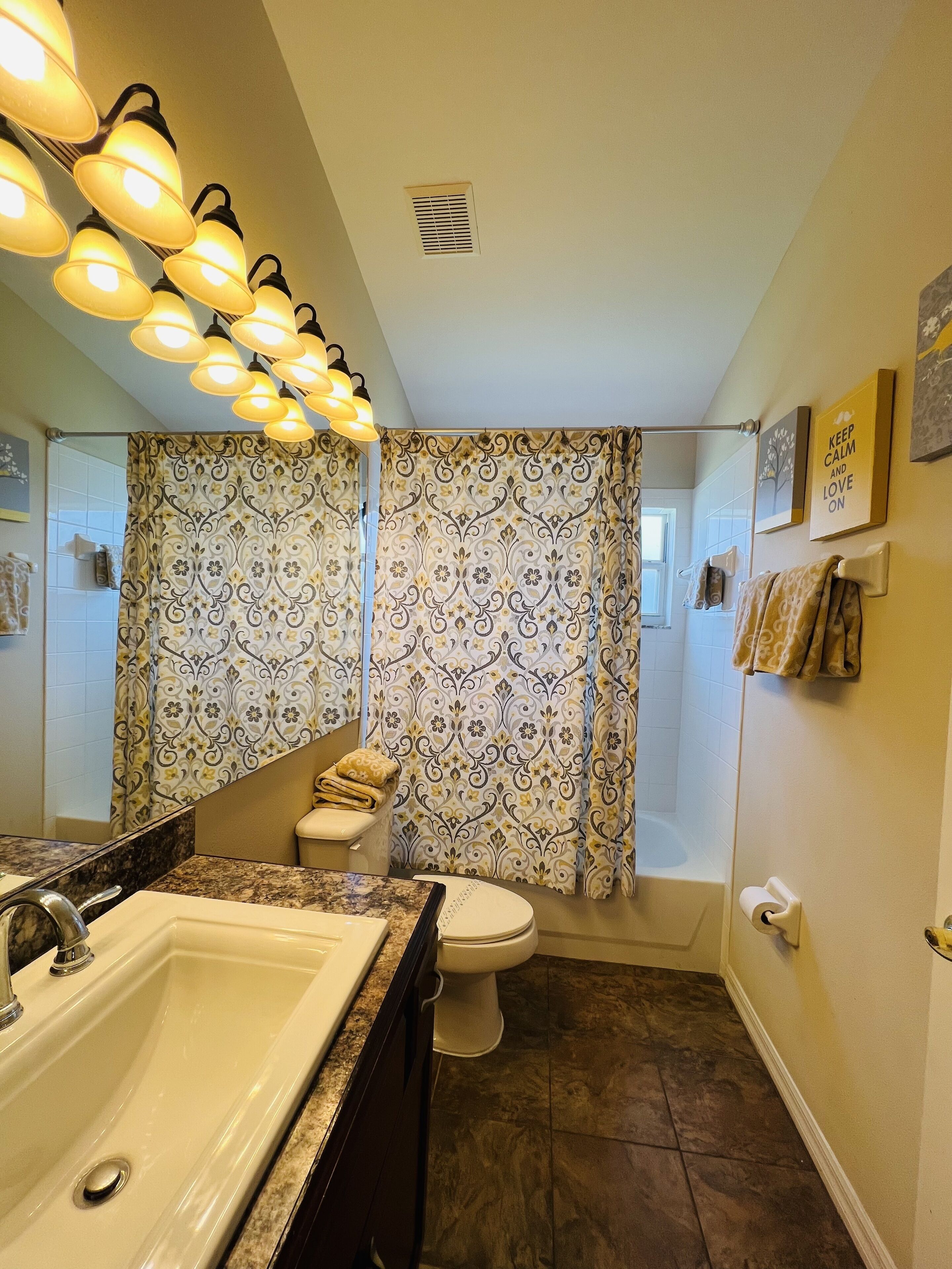 A bathroom with a sink, toilet, and shower curtain.