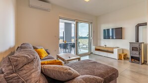 Una sala de estar moderna con un sofá, una mesa de centro, un televisor y una chimenea.