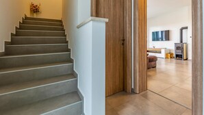 Una escalera conduce a una sala de estar con chimenea y televisor de pantalla plana.