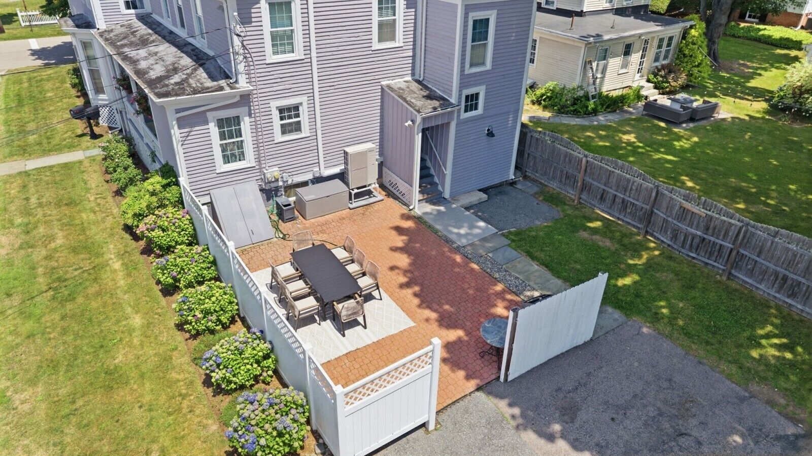 A residential property with a patio, outdoor seating, and a fenced yard.