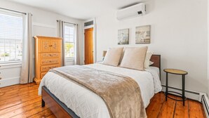 Un dormitorio con una cama de madera, un aparador y una mesita.