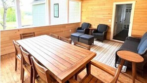A wooden interior with a dining table and chairs, a ceiling fan, and a seating area with sofas and a coffee table. - 4BD 4.5BA Pet-Friendly Riverfront Home (Saco)