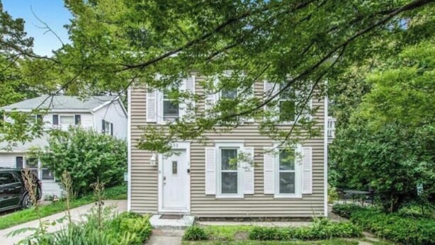 A two-story house with a front porch, a driveway, and a car parked in the driveway. - #3 Bright 1-Bdrm suite downtown with parking (Saugatuck)