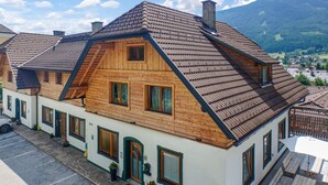Une maison de style chalet traditionnel, dotée d’un toit à forte pente, d’une façade en bois et de nombreuses fenêtres.