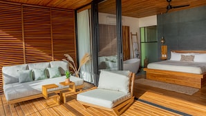 A modern interior with a wooden ceiling, a sofa with cushions, a small table, and a bed with a mattress and pillows. - The L Design Villa (Santa Teresa de Cobano)