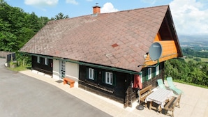 A house with a sloped roof, a satellite dish, and a patio with outdoor furniture. - Ferienhaus mit Landblick (Oberhaag)