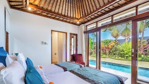 Un dormitorio con dos camas, un ventanal y vista a una piscina.