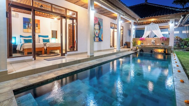 Un espace aménagé au bord de la piscine offrant une vue dégagée sur une chambre avec deux lits, une grande peinture et un mur décoratif.