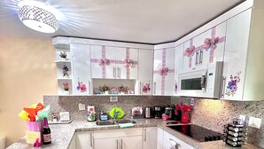 A kitchen with white cabinets, a microwave, and a sink. - Boutique Guest House – Private Patio Oasis – Near Beach – Family-Friendly (North Miami)